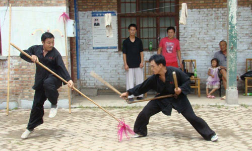 two marital artists fighting with sticks