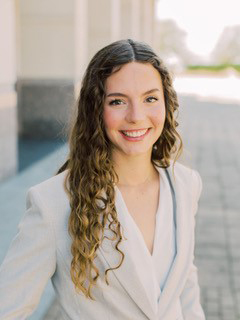 Texas A&M senior Grace Vaughn is all smiles, standing outside the Jon L. Hagler Center on the Texas A&M University campus