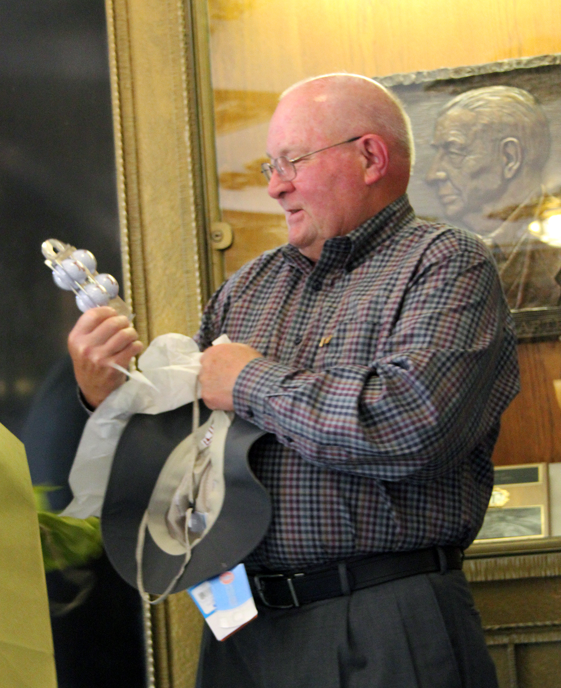Texas A&M chemist John Fackler admires a custom set of golf balls, one of several gifts he was presented with at his 80th birthday celebration in the Texas A&M Chemistry Building.