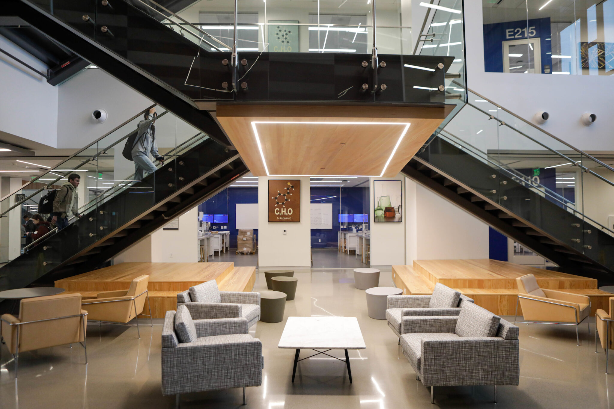 Interior view of the Instructional Laboratory and Innovative Learning Building at Texas A&M University showing students ascending the main staircase in the foyer and various seating areas