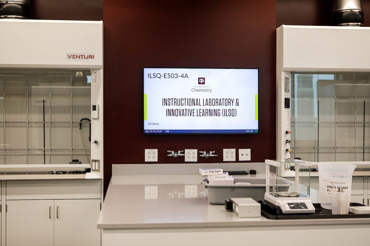Close-up view of a work station in an organic chemistry laboratory within the Instructional Laboratory and Innovative Learning Building at Texas A&M University featuring a computer, fume hoods and assorted laboratory equipment