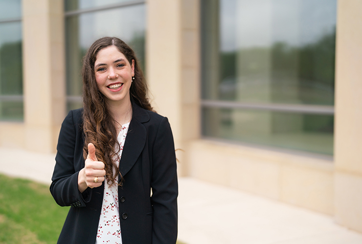 Texas A&M senior Emily Orr flashes a gig 'em outside the Hagler Center