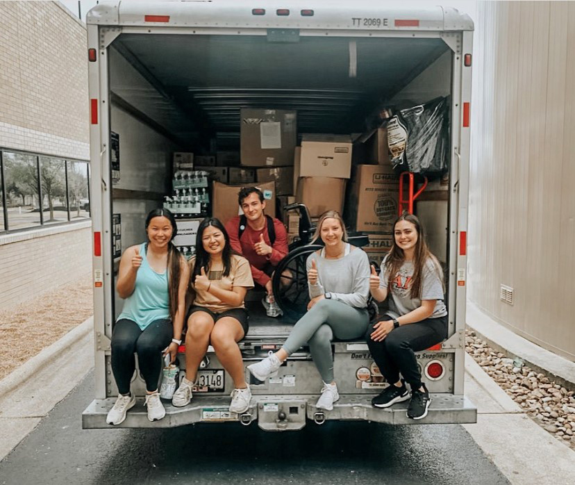 Texas A&M biomedical sciences major Mya Phelps and other VOOM Ambassadors, sitting in the back of a U-Haul full of packaged medical supplies