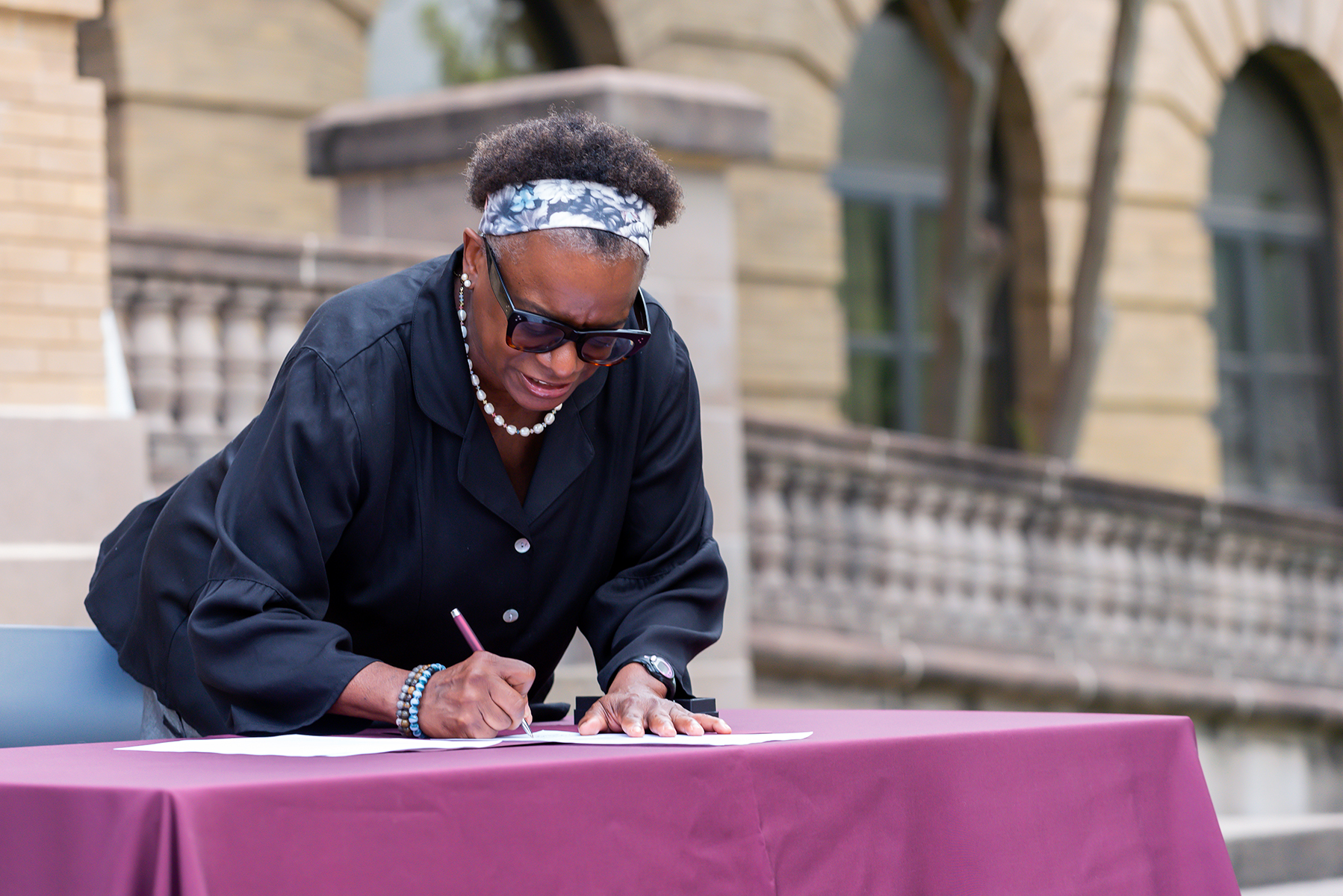Dr. Kathleen McElroy signs her appointment letter naming her director of the Texas A&M Journalism Program