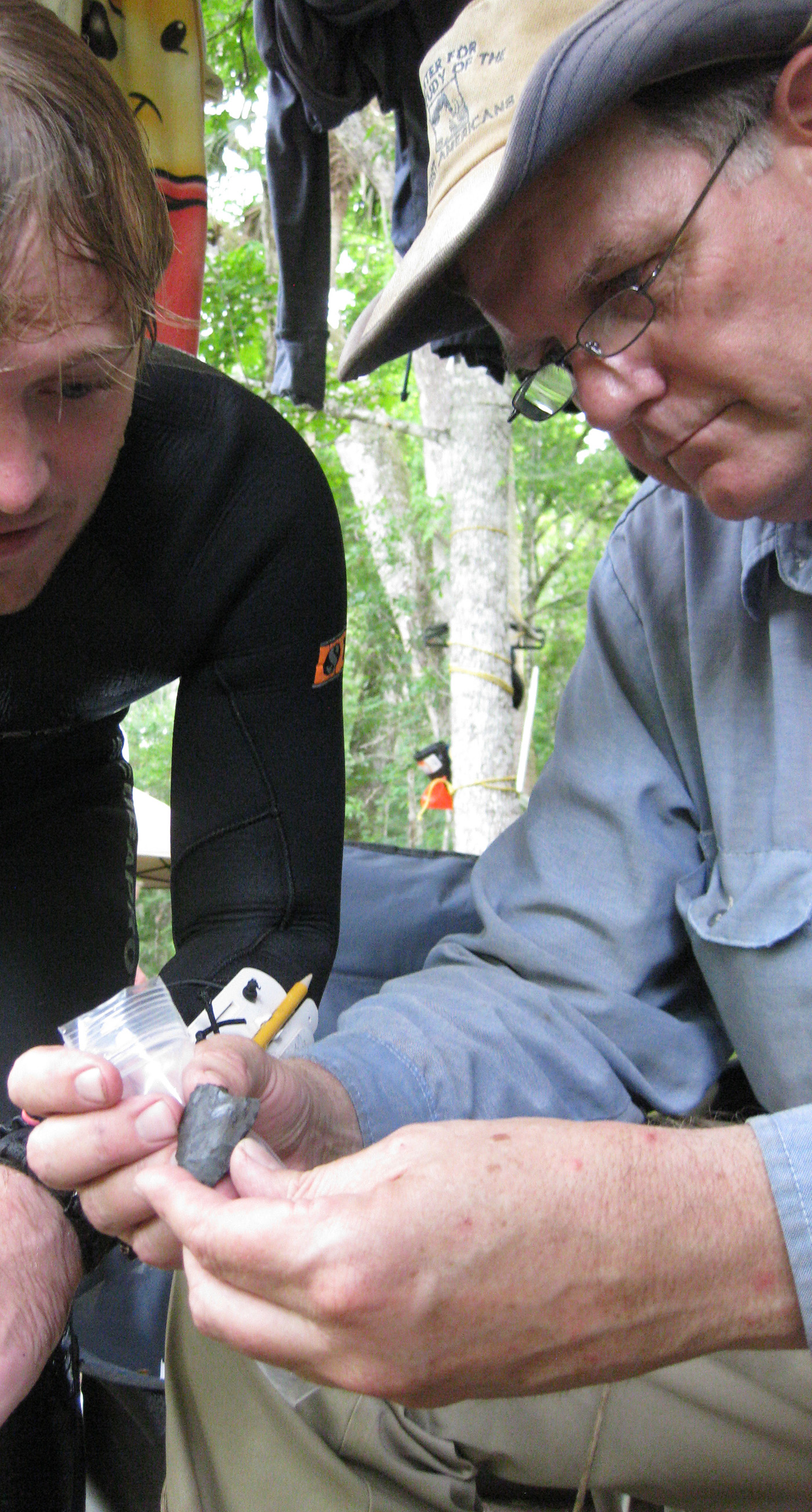 Texas A&M archaeologist Michael Waters and graduate student Morgan Smith examine a 14,600-year-old knife found at the Page-Ladson site in Florida