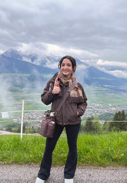 Texas A&M meteorology student Taylor Peña flashes a gig 'em for the camera with the Alps in the background