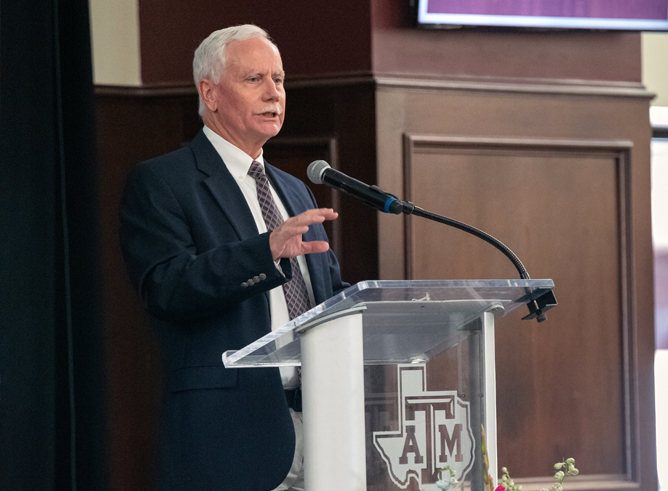 Texas A&M biologist Mark Zoran at the podium in The Zone Club at Kyle Field