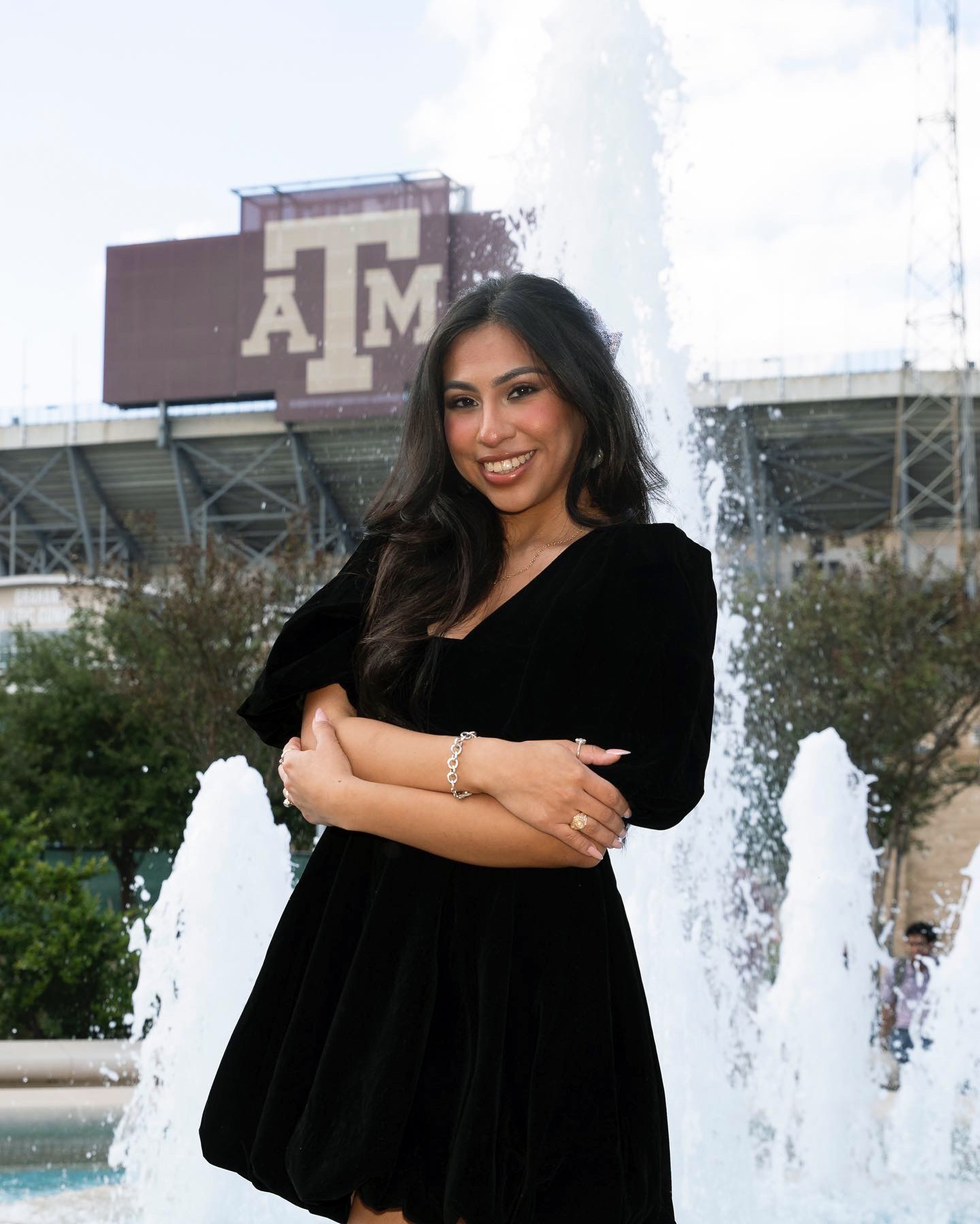 Texas A&M women's and gender studies major Odyssey Olmos poses after receiving her Aggie Ring with the jumbotron at Kyle Field in the background