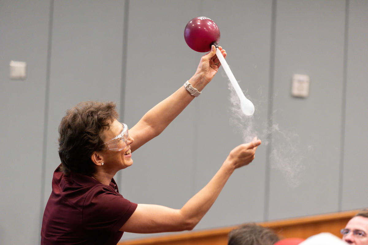 Texas A&M physicist Tatiana Erukhimova shows the effect of liquid nitrogen on a balloon during the 2023 Mitchell Institute Physics Enhancement Program for high school physics teachers