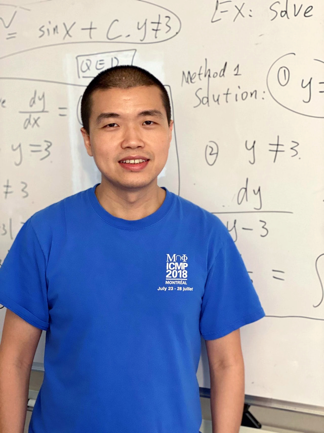 Texas A&M University mathematician Wencai Liu, standing in front of a white board filled with hand-written mathematical formulas