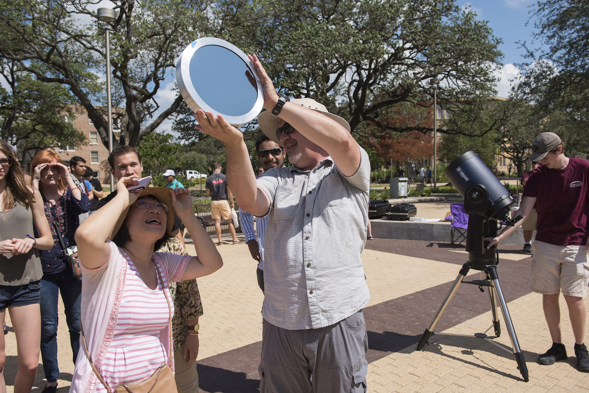 Texas A&M University astronomer Darren DePoy assists a line of participants in viewing the solar eclipse from Rudder Plaza on the Texas A&M campus on August 21, 2017