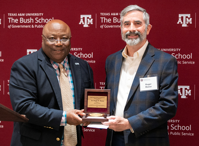 Texas A&M University history professor Roger Reese accepts his award from Bush School Interim Dean Dr. Frank Ashley