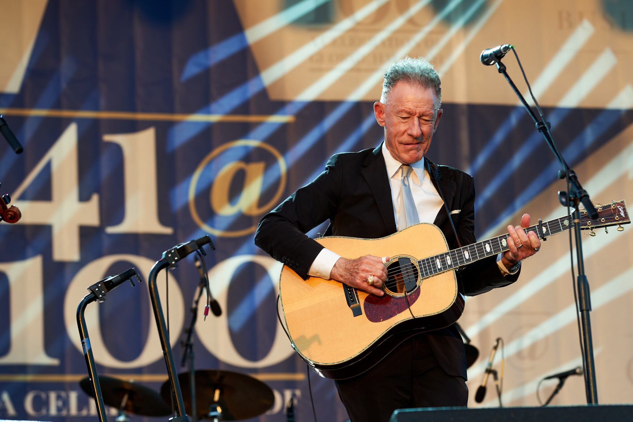 Close up of Texas A&M University former student and musician Lyle Lovett performing on stage on the grounds of the George H.W. Bush Presidential Library and Museum during the Bush 41@100 Centennial Celebration on June 13, 2024