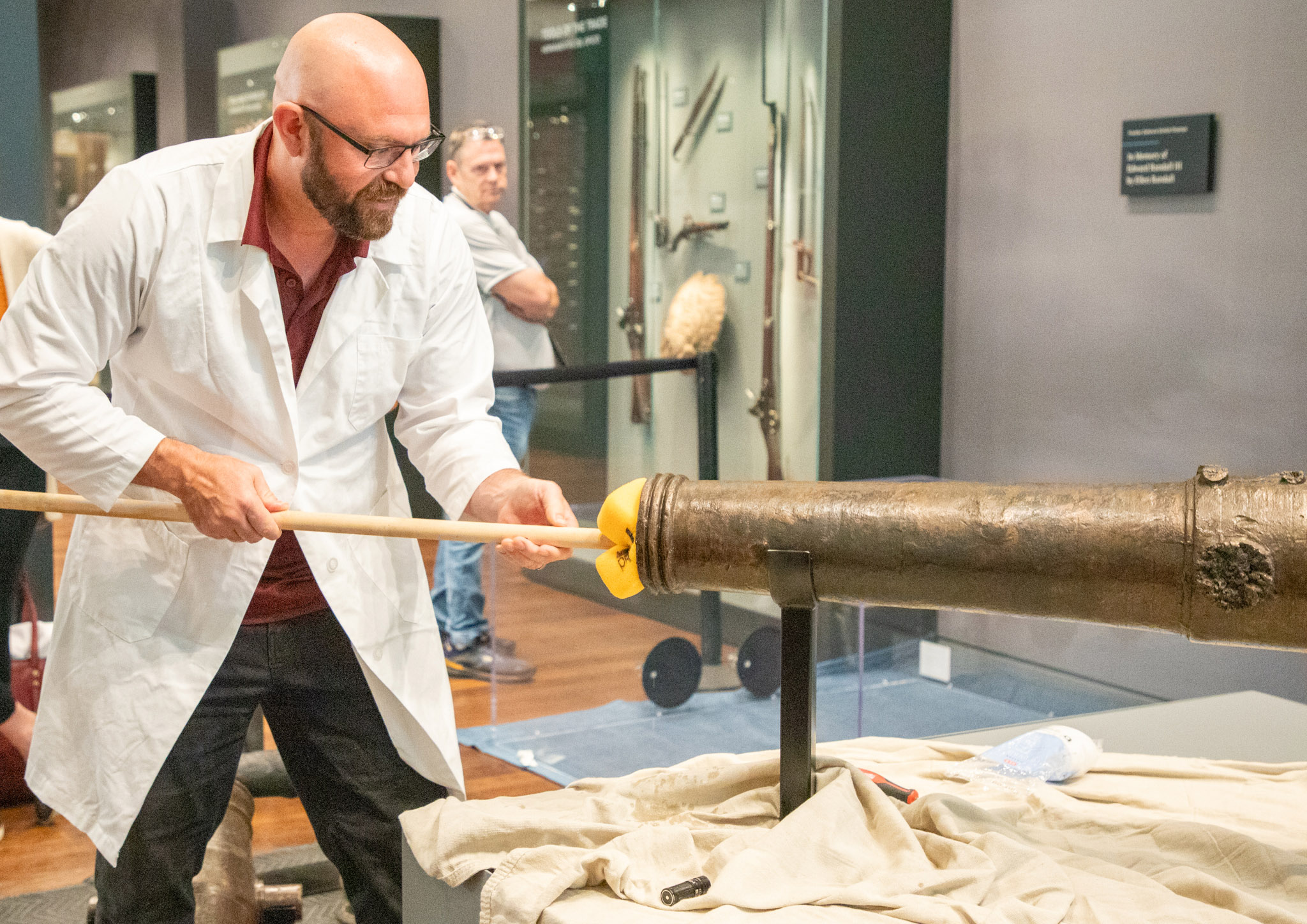 Texas A&M University anthropologist and nautical archaeologist Chris Dostal swabs the bore of a four-pound bronze cannon used in the Battle of the Alamo