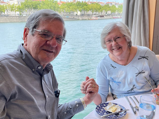 Texas A&M University former student and statistician Dr. William B. Smith and Patricia Smith hold hands while dining near a waterfront