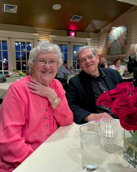 Texas A&M University statistician Dr. William B. Smith and his wife Patricia Smith, sitting together at a dining table adorned with red roses