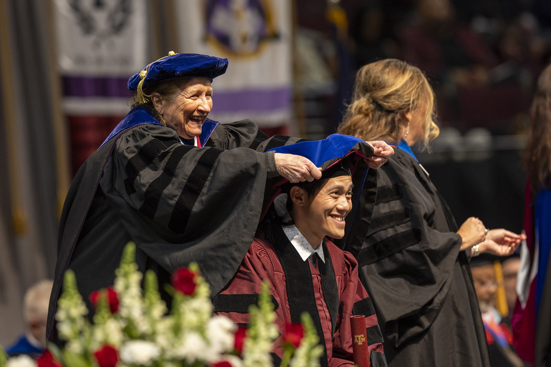 Texas A&M University chemist Marcetta Darensbourg places a hood on one of her graduating doctoral students, Dr. Trung Le, during commencement ceremonies in Reed Arena on December 15, 2023