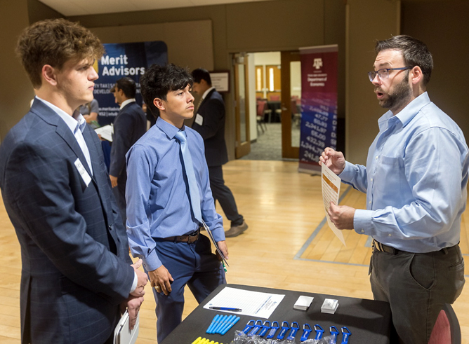 Two Texas A&M University economics majors speak with a recruiter at the 2024 Economics Career Fair, held September 25 in the Memorial Student Center on the Texas A&M campus