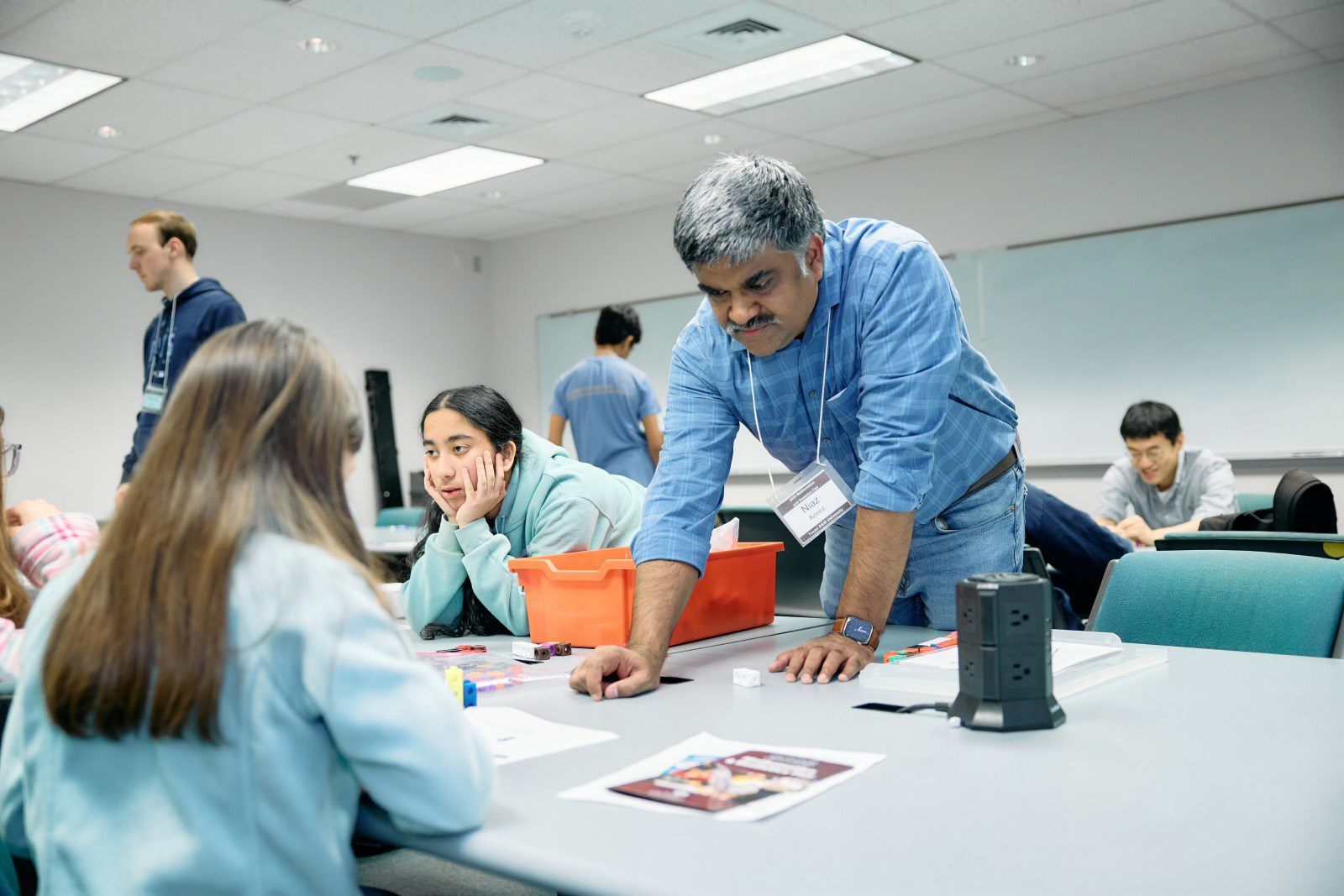 Niaz Azeez ’26 facilitating a workshop discussion with young participants in a classroom setting.