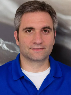 Portrait of an individual wearing a blue shirt, with a backdrop featuring a blurred image of Earth from space.