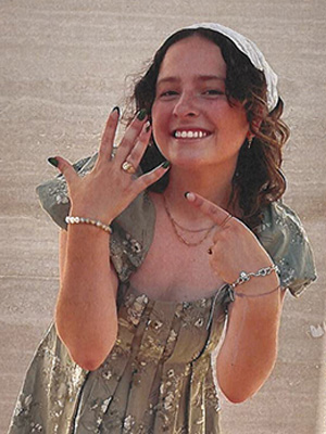 Ruffy points to her new Aggie ring, wearing a green floral dress.
